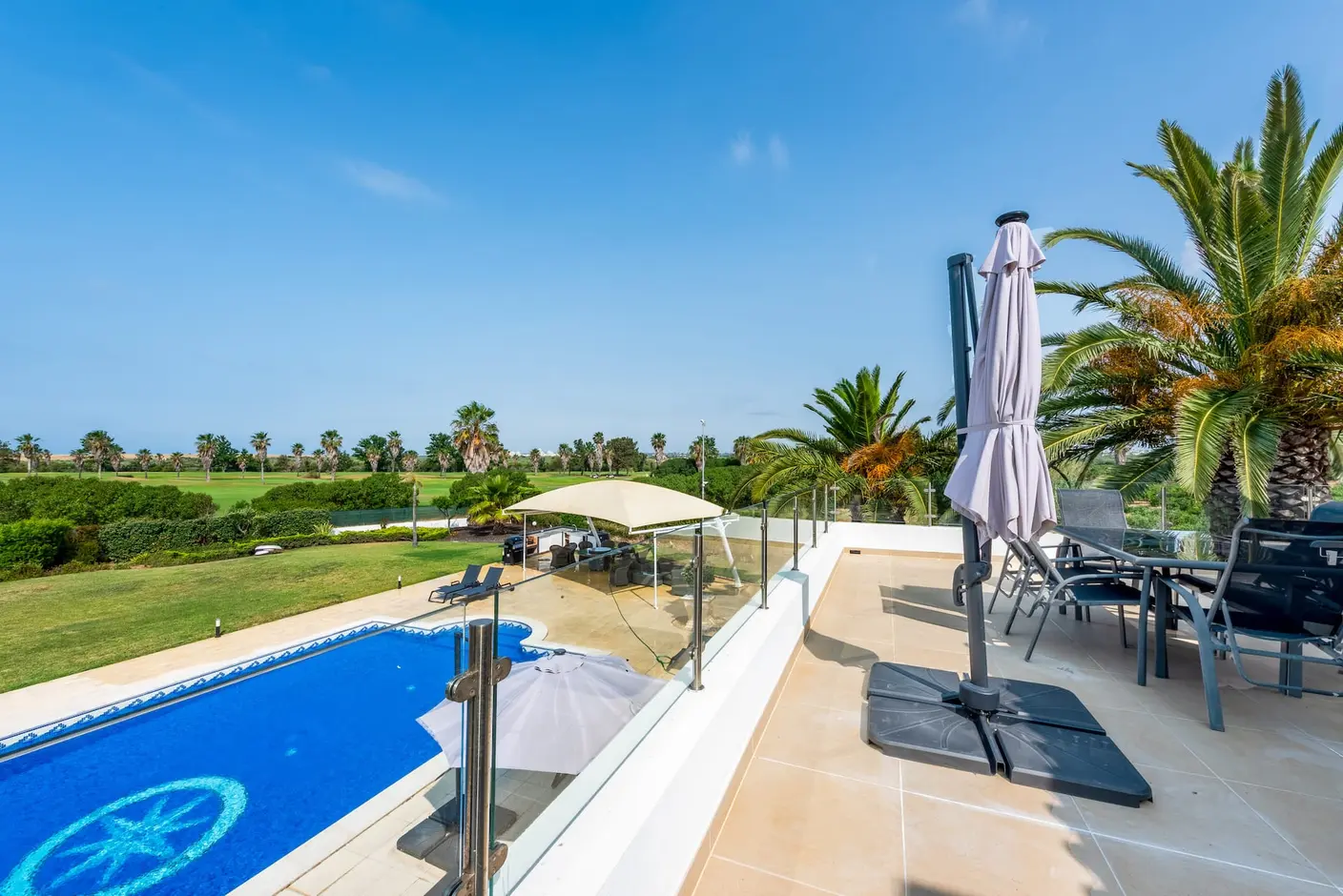 Vue depuis la terrasse de Villa Vera sur la piscine et le jardin